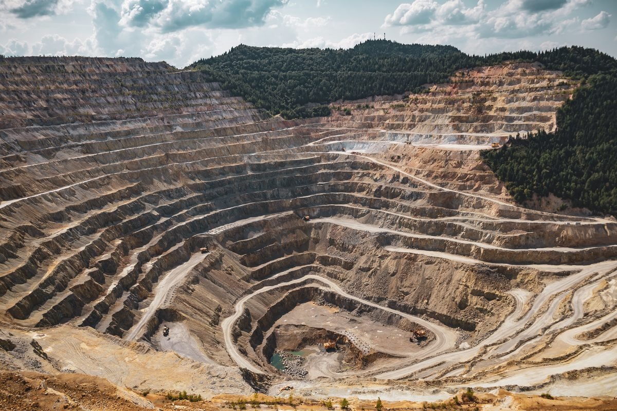 Terraced open-pit mine with haul roads and operating equipment